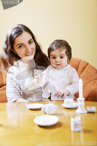 Image of Smiling mother playing with daughter