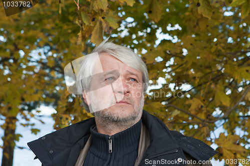 Image of Portrait of middle-aged man in autumn day.