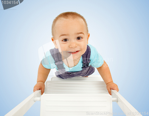 Image of Little boy walking on ladder