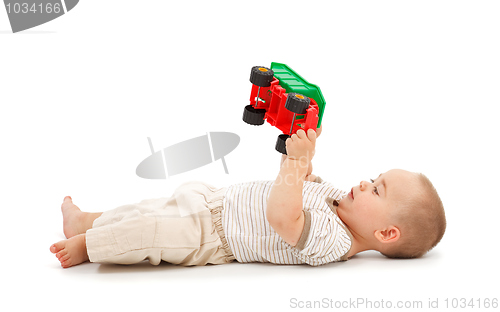 Image of Boy playing with plastic toy car