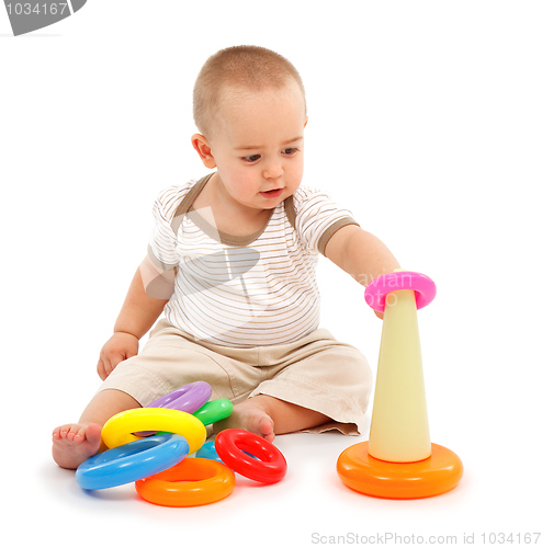 Image of Little boy sitting and playing