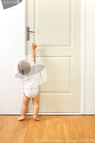 Image of Baby boy in front of door