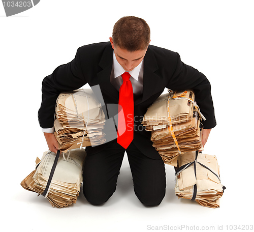 Image of Tired businessman with lots of paperwork