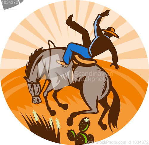 Image of cowboy falling off horse