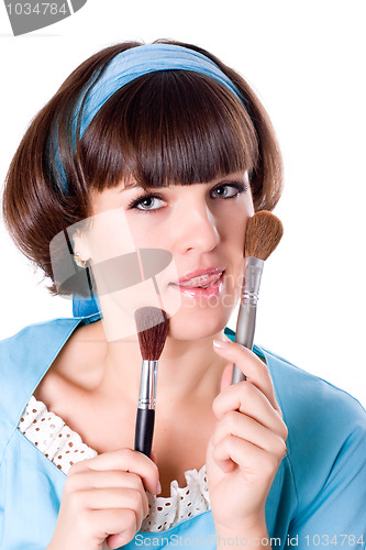 Image of  woman in blue dress with two make-up brushes