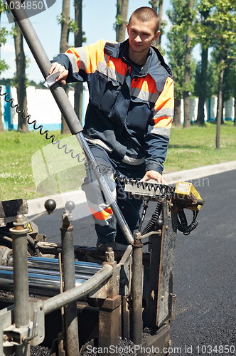 Image of Young paver worker at asphalting works