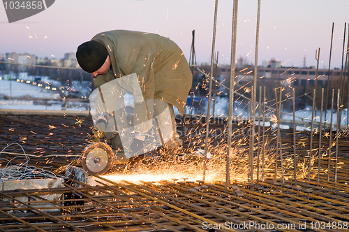 Image of Builder with cutoff saw and sparkles