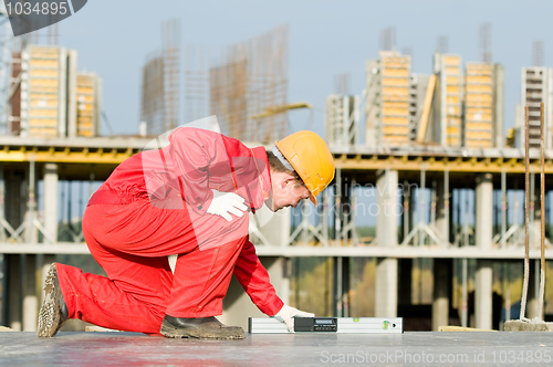 Image of builder with digital level