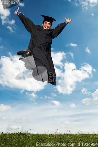 Image of happy jumping graduate outdoors