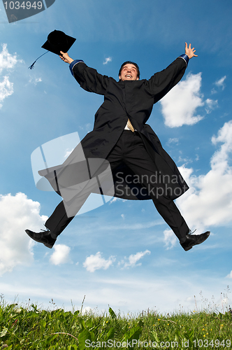 Image of happy jumping graduate outdoors