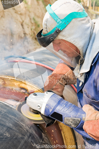 Image of laborer and grinder machine