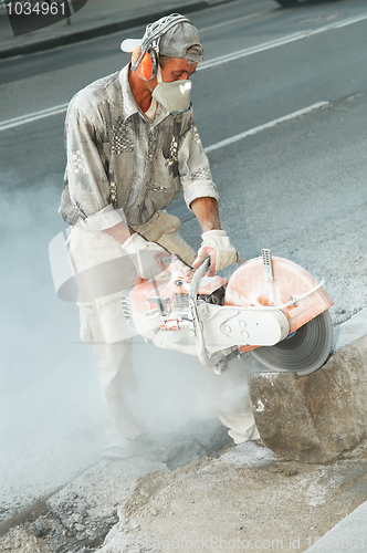 Image of builder at stone cutting work