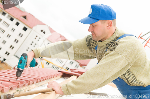 Image of roofing works with screwdriver
