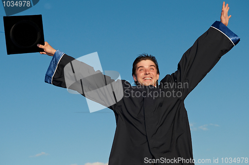 Image of graduate with open arms outdoors