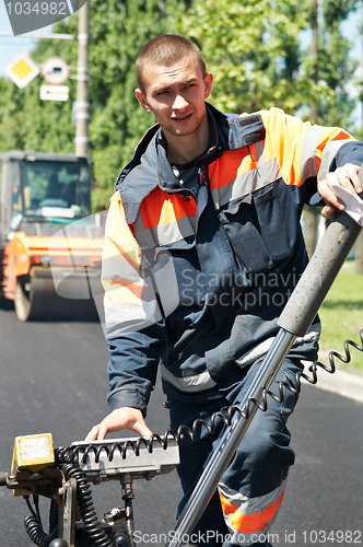 Image of Young paver worker at asphalting works