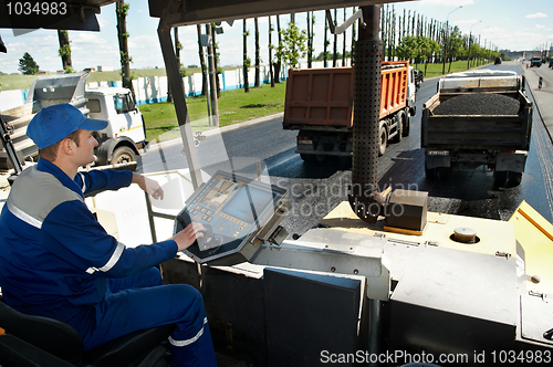 Image of Asphalt spreading machine worker