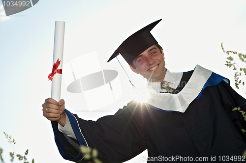 Image of graduate with a diploma in backlight