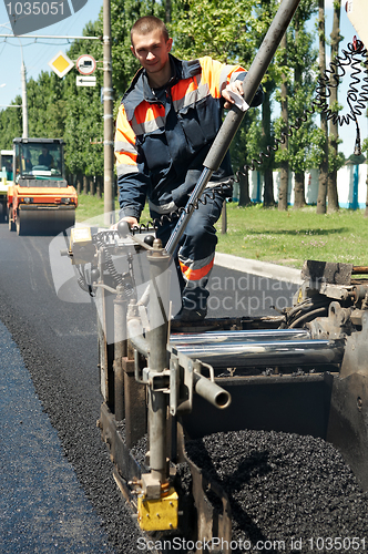 Image of Young paver worker at asphalting works