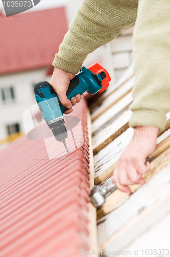 Image of roofing works with screwdriver