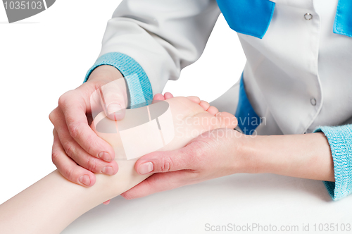 Image of Masseur massaging a child leg