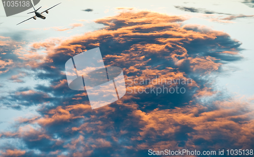 Image of airplane over Sunset cloudscape