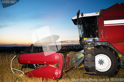 Image of harvesting combine at sunset