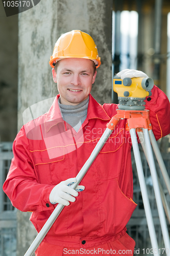 Image of smiling surveyor builder and level