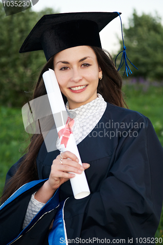 Image of Happy Young smiley graduate girl outdoors