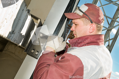 Image of builder with wrench and screws
