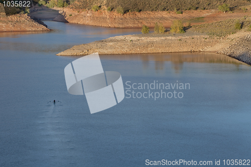 Image of lonely rower on a mountain lake