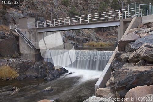 Image of diversion dam on a mountain river flowing in deep, dark canyon