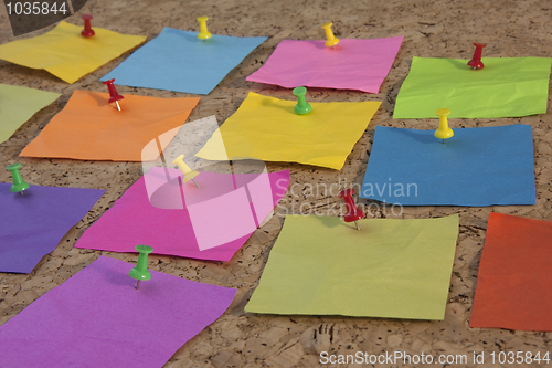 Image of colorful blank sticky notes on cork board