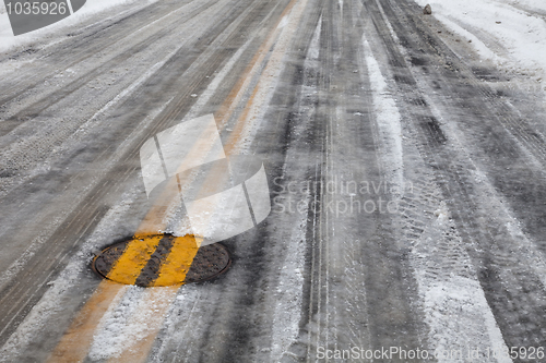 Image of slippery icy road with yellow line