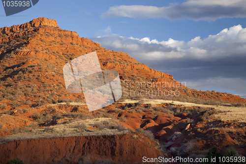 Image of eroded red mountain with sparse vegetation