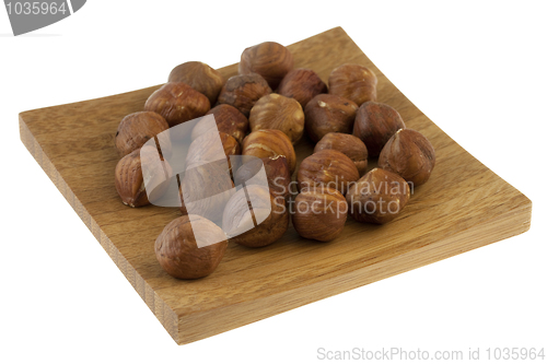 Image of handful of filberts (hazelnuts) on a small wooden tray