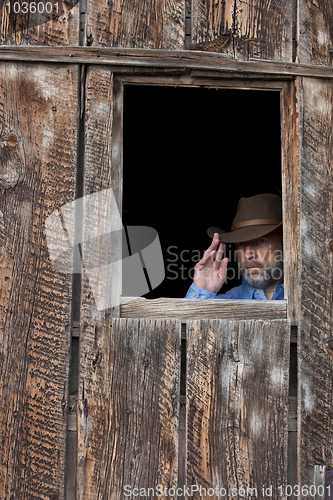 Image of cowboy in a dark window of old barn