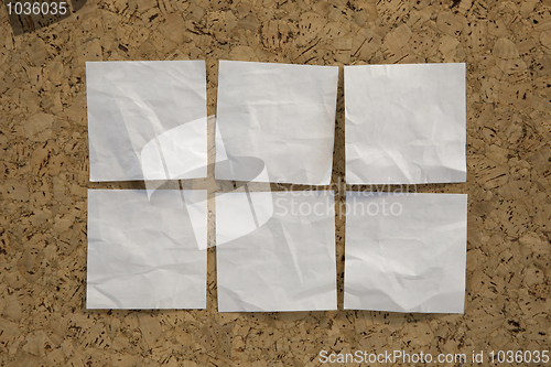 Image of six blank white reminder notes on cork board