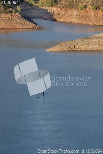 Image of lonely rower on a mountain lake