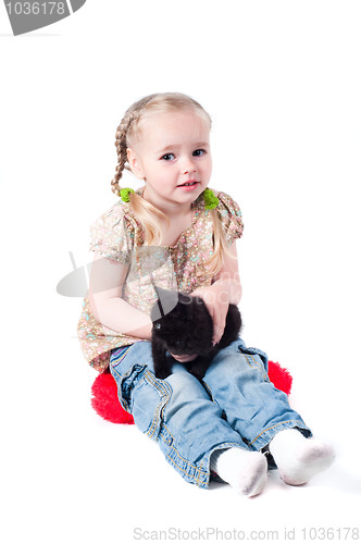 Image of Little girl playing with kitten