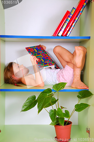 Image of child reading a book in a bookcase