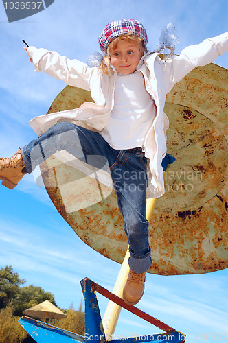 Image of autumn coat and hat dressed child jumping