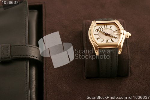 Image of gold watch with black strap 