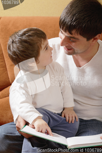 Image of Father reading book to daughter