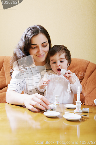 Image of Smiling mummy playing with daughter