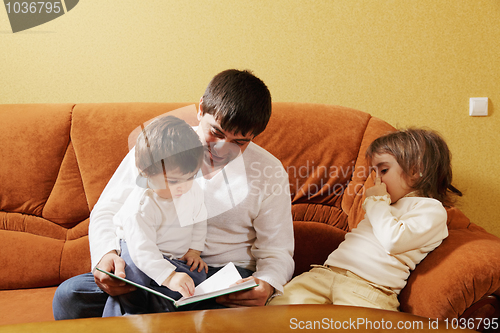 Image of Dad reading book to daughters