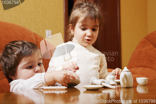 Image of Sisters playing with dishware