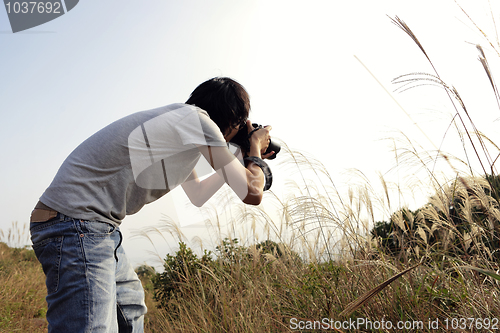 Image of nature photographer taking pictures outdoors