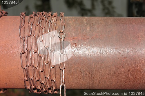 Image of Rusty chain wrapped around the metal cylinder