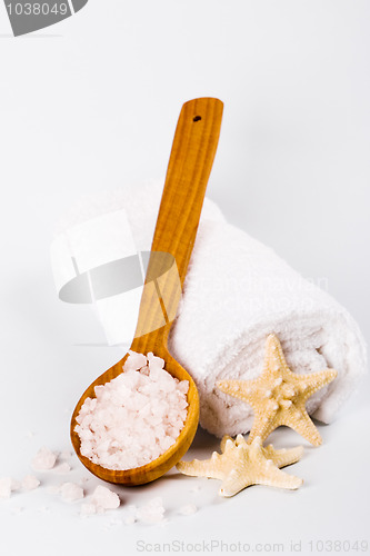 Image of  sea salt on wooden spoon, towel and starfish