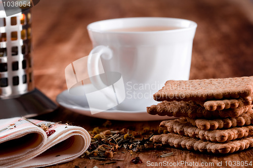 Image of french press, cup of fresh herbal tea and some cookies 